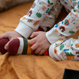 Child wearing the rainbow striped socks from the Little Green Radicals folk tales ankle socks 3 pack.