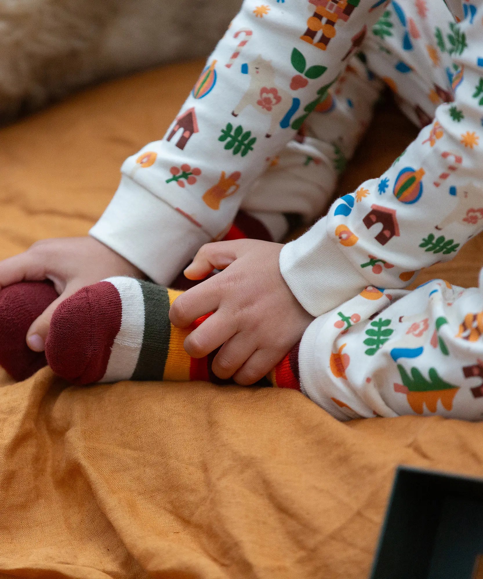 Child wearing the rainbow striped socks from the Little Green Radicals folk tales ankle socks 3 pack.