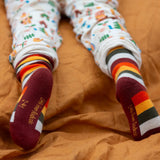 Child wearing the rainbow striped socks from the Little Green Radicals folk tales ankle socks 3 pack.