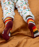 Child wearing the rainbow striped socks from the Little Green Radicals folk tales ankle socks 3 pack.