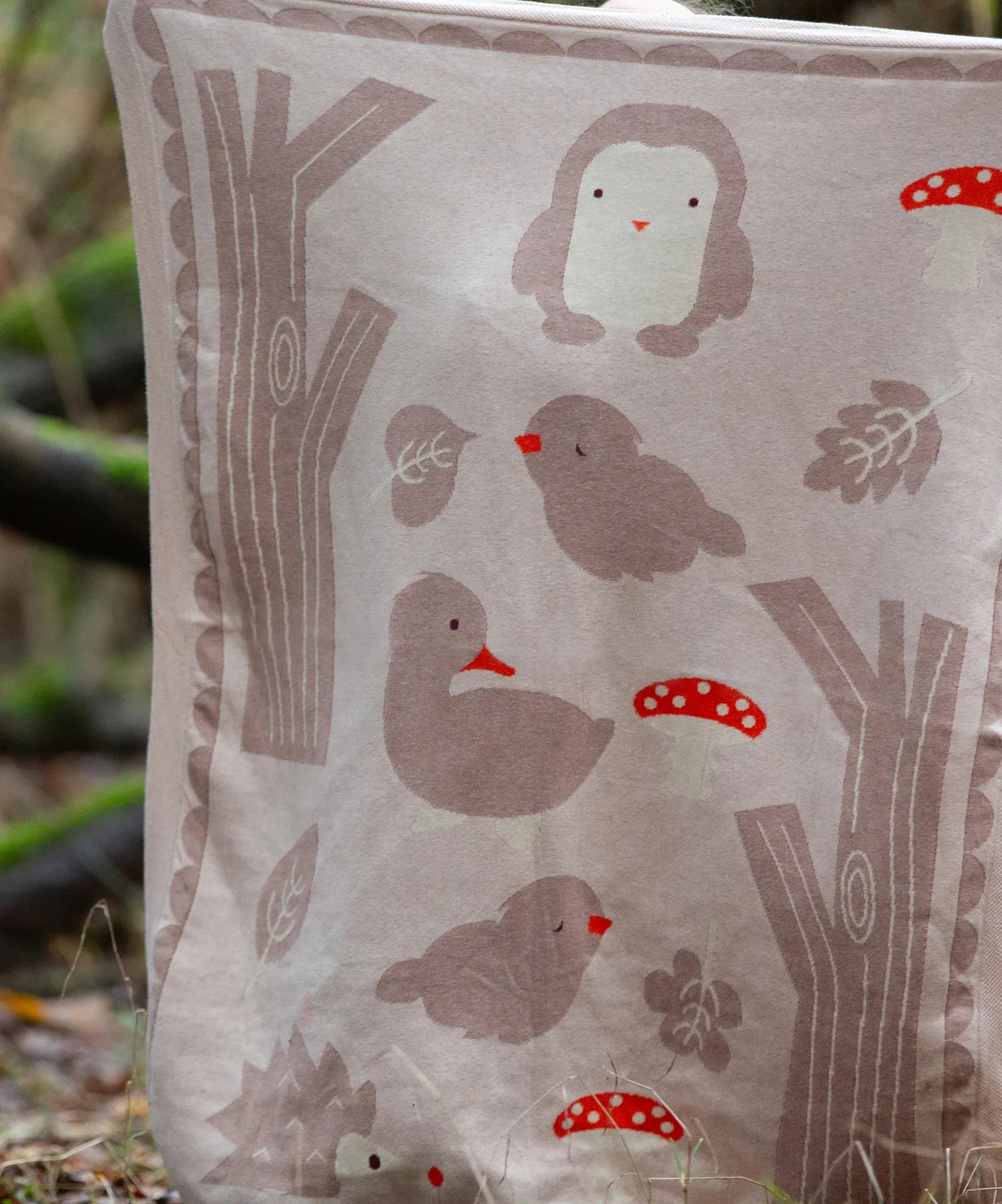 Close up of the design on the Little Green Radicals cream folk tales knitted organic cotton baby blanket.