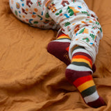 Child wearing the rainbow striped socks from the Little Green Radicals folk tales ankle socks 3 pack.