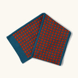 Little Green Radicals ginger squares design knitted scarf. Blue with ginger red squares pattern over it.