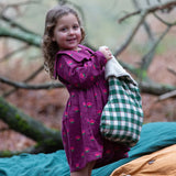 Child wearing the Little Green Radicals pink flowers sailor dress in purple with green wellington boots. 