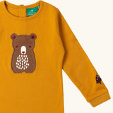 Close up of the bear applique on the front of the Little Green Radicals gold bear applique organic cotton long sleeve childrens top.