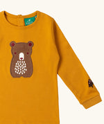 Close up of the bear applique on the front of the Little Green Radicals gold bear applique organic cotton long sleeve childrens top.