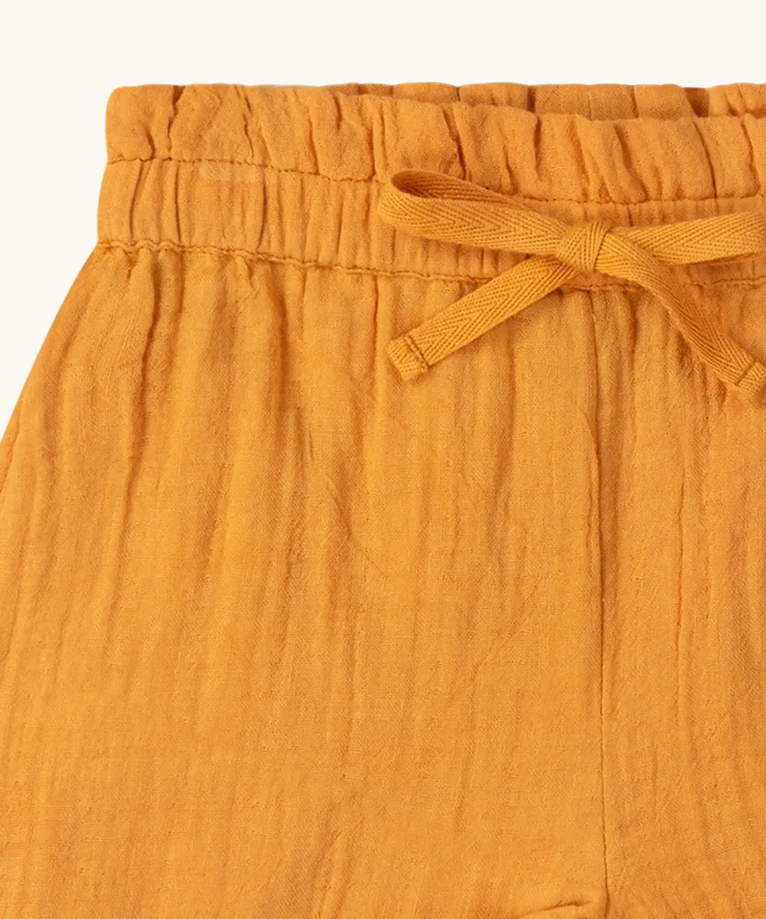 Close up of the waistband on the Little Green Radicals golden ochre yellow kids shorts organic cotton shorts.