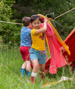 A child wearing the Little Green Radicals Yellow gold coloured Squirrel t-shirt with blue striped shorts. 