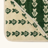 Little Green Radical hooded towel in green with a repeating fish design showing contrast cream inner lining 