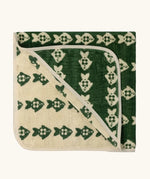Little Green Radicals GOTS organic cotton hooded towel in green and cream with a repeating fish design folded into a square