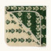 Little Green Radicals GOTS organic cotton hooded towel in green and cream with a repeating fish design folded into a square