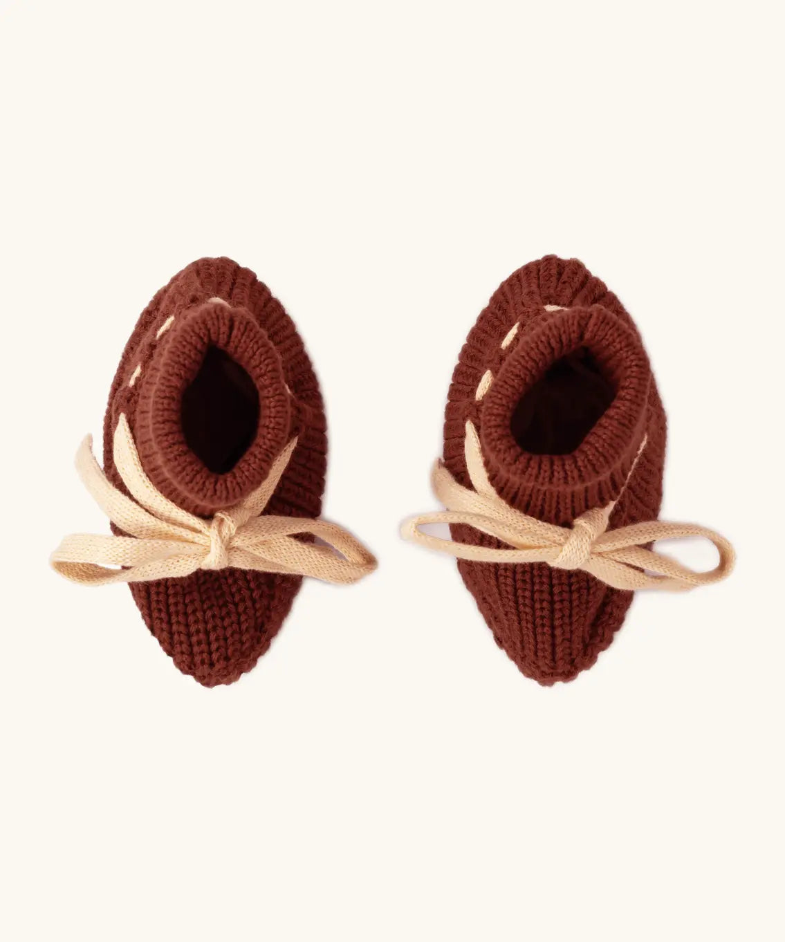 Overhead view of the Little Green Radicals hazelnut rust brown organic cotton knitted baby booties.