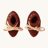 Overhead view of the Little Green Radicals hazelnut rust brown organic cotton knitted baby booties.