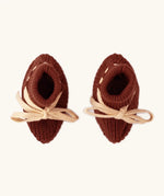 Overhead view of the Little Green Radicals hazelnut rust brown organic cotton knitted baby booties.