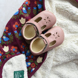 Little Green Radicals folk bird organic cotton hooded baby blanket with sherpa fleece lining with a pair of pink Froddo barefoot shoes p[laced on top.