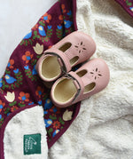 Little Green Radicals folk bird organic cotton hooded baby blanket with sherpa fleece lining with a pair of pink Froddo barefoot shoes p[laced on top.