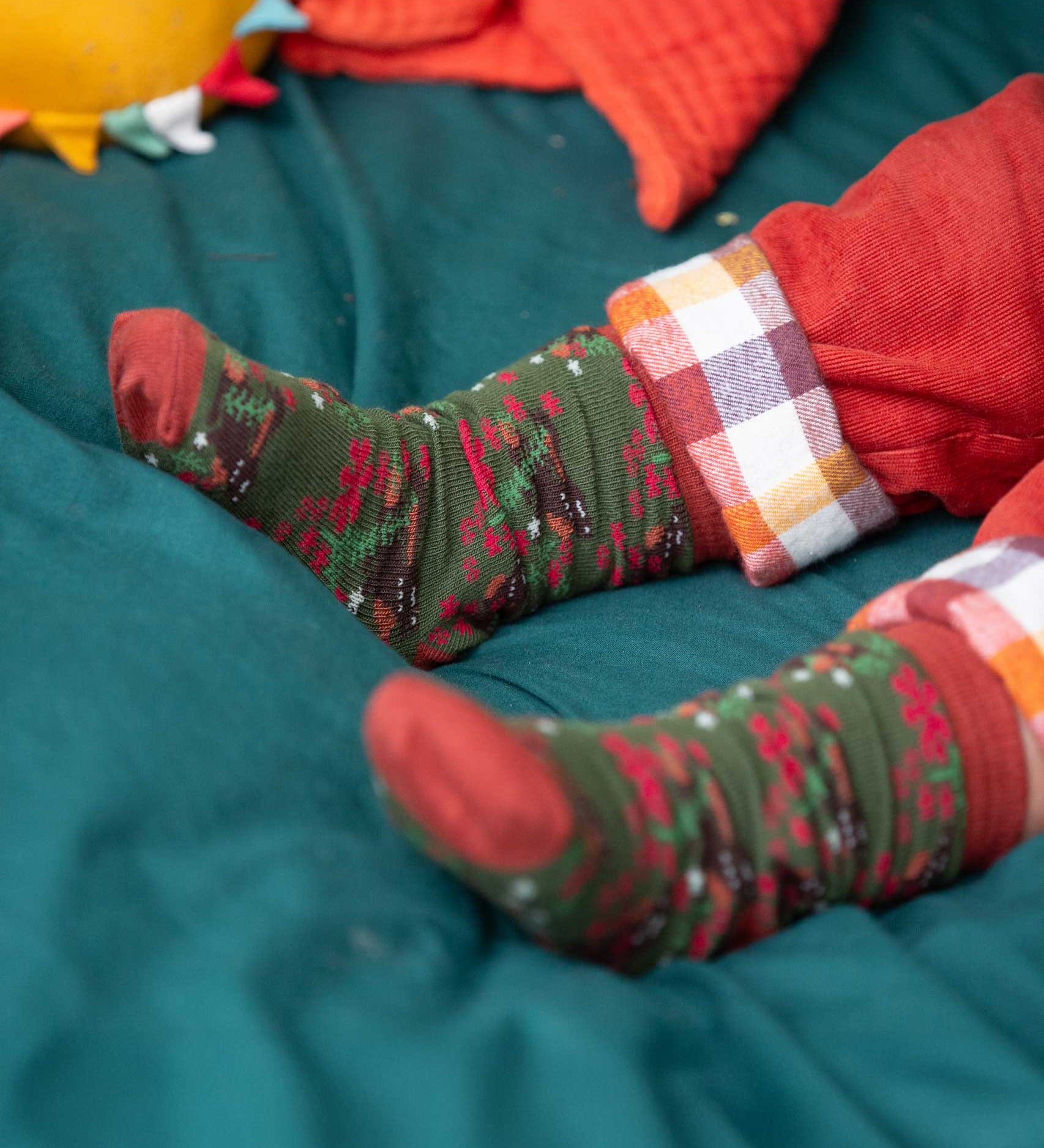 A close up of the winter rabbits design socks on a child's feet. Little Green Radicals Ankle Socks 3 Pack - Winter Rabbits. The organic cotton children's socks are a part of a wide range of organic cotton clothing for children available here at Babipur. 