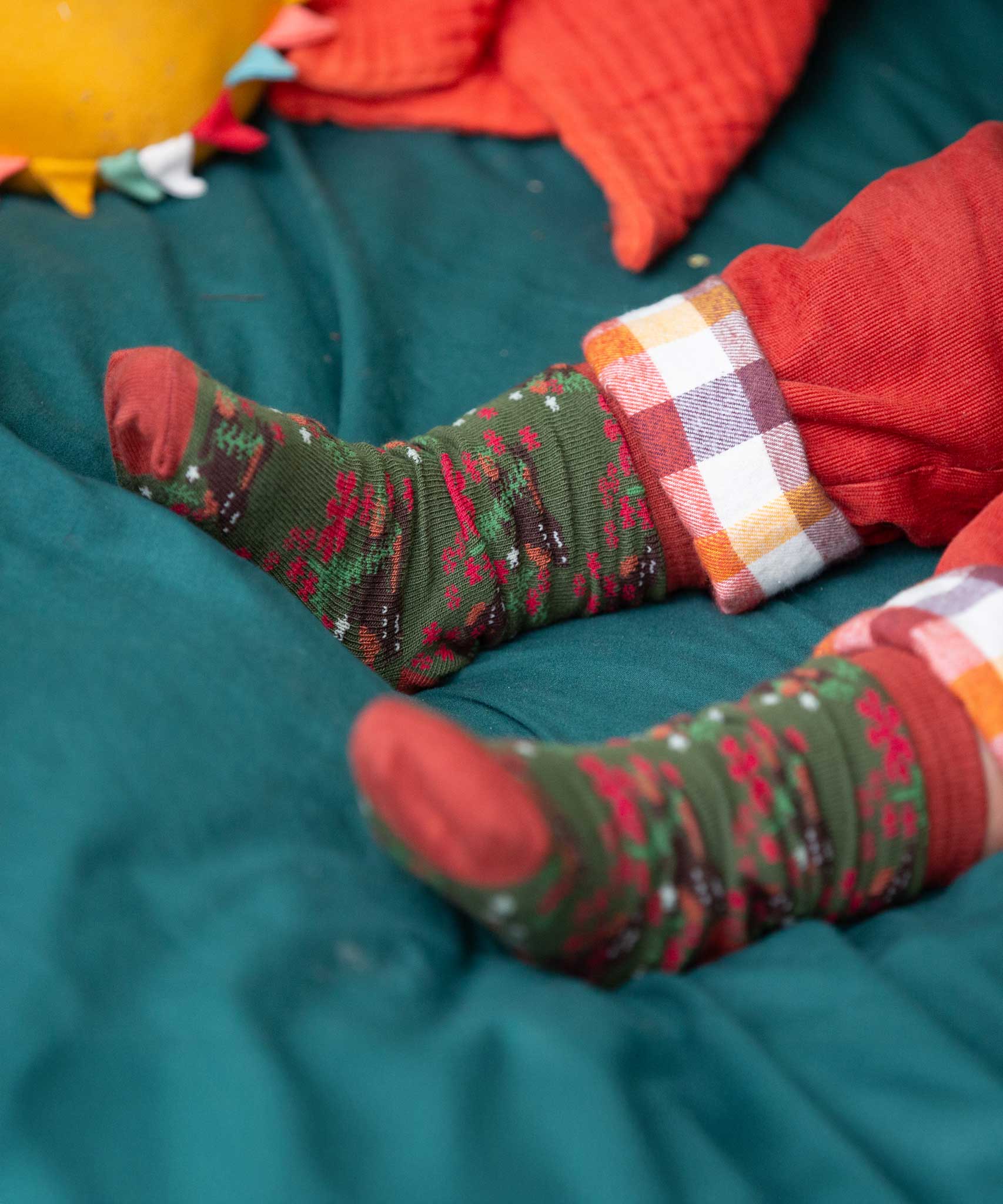 A close up of the winter rabbits design socks on a child's feet. Little Green Radicals Ankle Socks 3 Pack - Winter Rabbits. The organic cotton children's socks are a part of a wide range of organic cotton clothing for children available here at Babipur. 