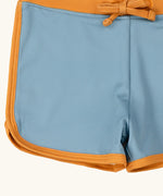 Close up of the yellow gold binding on the Little Green Radicals hazy blue kids swim shorts.