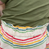 Close up of the elasticated waist on the Little Green Radicals children's cream rainbow striped by the sea twill shorts being worn. 