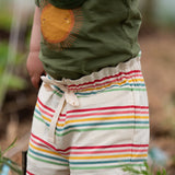 Close up of the waist tie on the Little Green Radicals children's cream rainbow striped by the sea twill shorts being worn. 