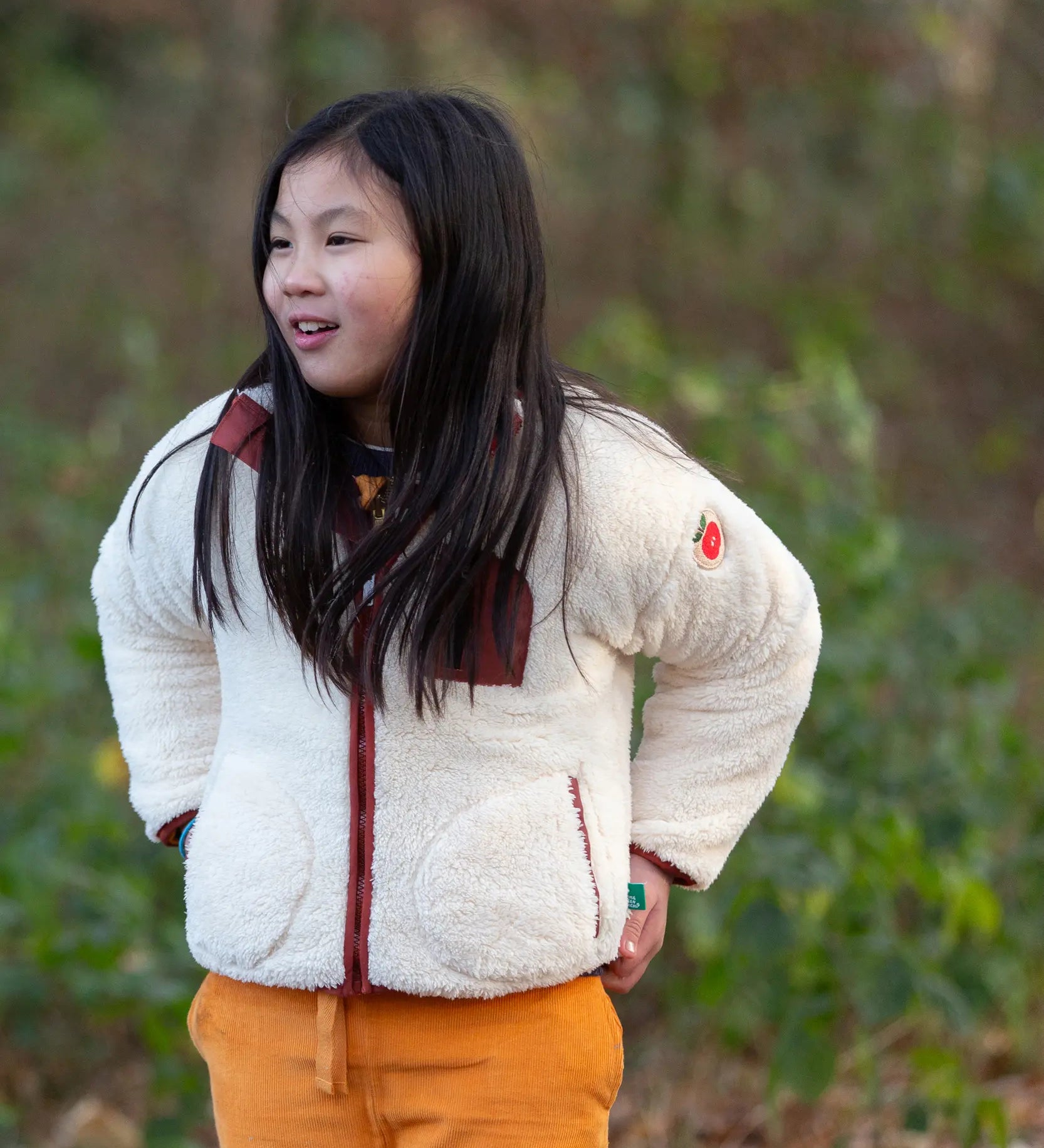 Child wearing a Little Green Radicals cream zip up cosy recycled fleece jacket.