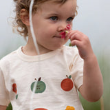 Close up of the nature illustrations on the front of the Little Green Radicals cream vintage style kids organic cotton t-shirt being worn.