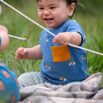 A child wearing the Little Green Radicals Kids' Organic T-shirt and Joggers Playset outfit in the  Blue Rainbows design. 