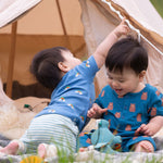 A child wearing the Little Green Radicals Kids' Organic T-shirt and Joggers Playset outfit in the  Blue Rainbows design. 