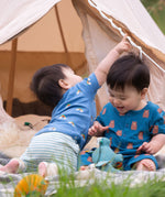 A child wearing the Little Green Radicals Kids' Organic T-shirt and Joggers Playset outfit in the  Blue Rainbows design. 