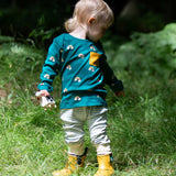 A child wearing the Little Green Radicals Kids' Organic Top and Joggers Playset in the Turquoise Rainbows design. This play set is part of a wide range of organic cotton clothing for children available here at Babipur. 