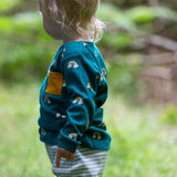 A side on view of a child wearing the Little Green Radicals Kids' Organic Top and Joggers Playset in the Turquoise Rainbows design. This play set is part of a wide range of organic cotton clothing for children available here at Babipur. 