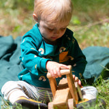 A child wearing the Little Green Radicals Kids' Organic Top and Joggers Playset in the Turquoise Rainbows design. This play set is part of a wide range of organic cotton clothing for children available here at Babipur. 