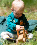 A child wearing the Little Green Radicals Kids' Organic Top and Joggers Playset in the Turquoise Rainbows design. This play set is part of a wide range of organic cotton clothing for children available here at Babipur. 