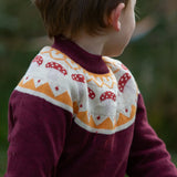 Close up of child wearing the Little Green Radicals knitted organic cotton jumper with a mushroom Fair Isle design.