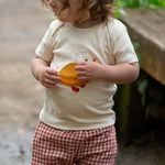 A child wearing the Little Green Radicals Little Duck Applique Short Sleeve T-Shirt with .ed and white gingham shorts. 