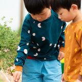 Child wearing the Little Green Radicals midnight moon print blue raglan organic cotton children's sweatshirt.