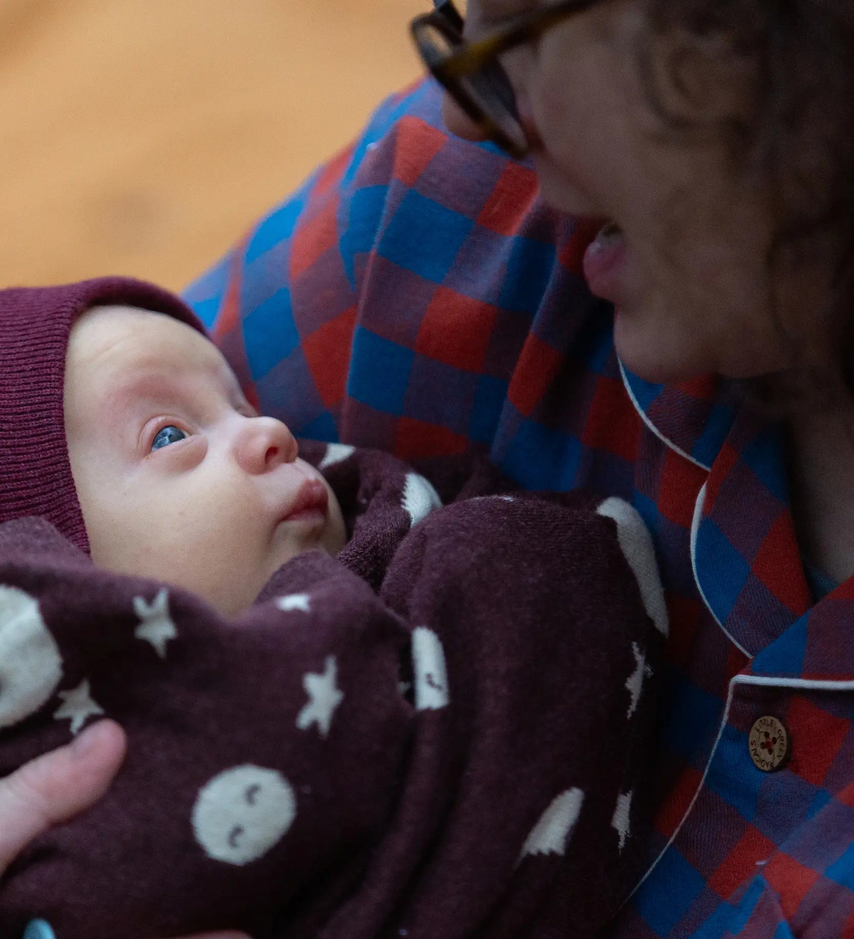 Baby wrapped up in a Little Green Radicals moon brown knitted organic cotton baby blanket.