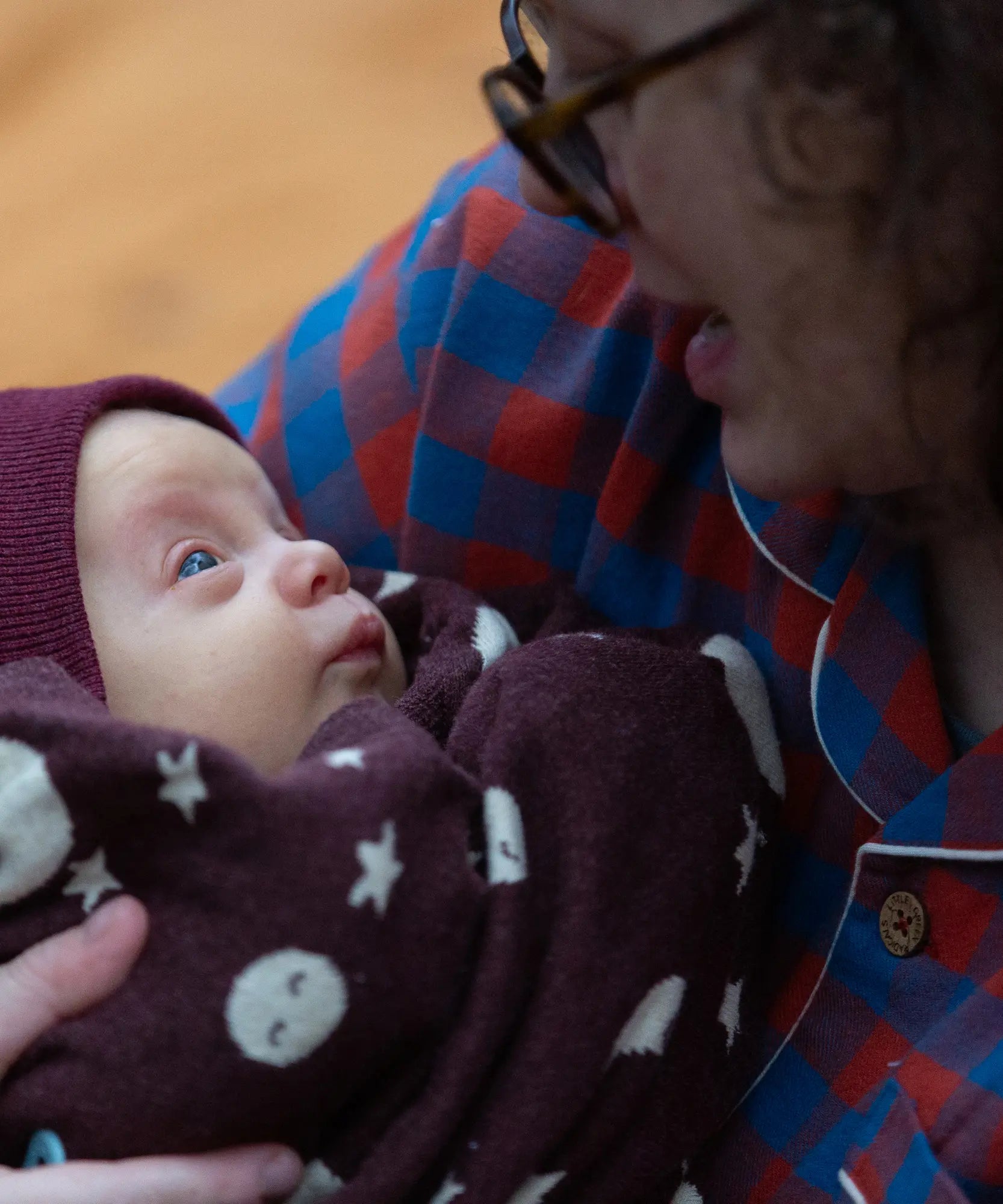 Baby wrapped up in a Little Green Radicals moon brown knitted organic cotton baby blanket.