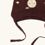 Close up of the chin strap ties on the Little Green Radicals brown organic cotton moon knitted bobble hat.