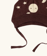 Close up of the chin strap ties on the Little Green Radicals brown organic cotton moon knitted bobble hat.