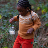 Child wearing the Little Green Radicals mountain Fair Isle snuggly woollen jumper in yellow gold with orange corduroy trousers.