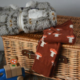 Little Green Radicals mushroom organic cotton knitted joggers placed on a wicket hamper with a Patagonia fleece in the background.