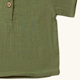 Close up of the hemline on the Little Green Radicals Muslin Loose Fit Short Sleeve Henley Top in a  Chive Green colour way.