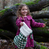Child holding a Little Green Radicals  olive green check organic cotton stocking.