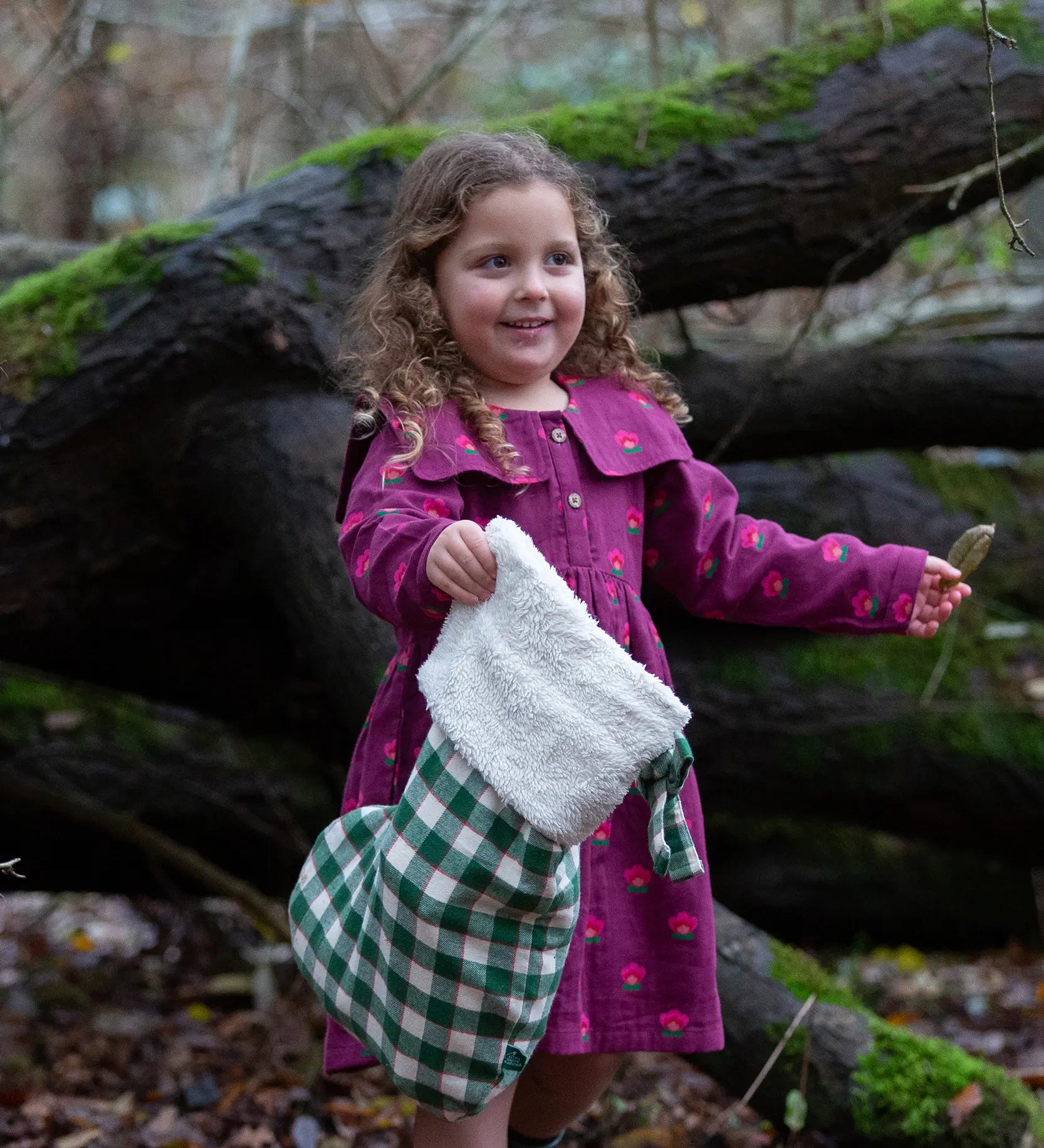 Child holding a Little Green Radicals  olive green check organic cotton stocking.