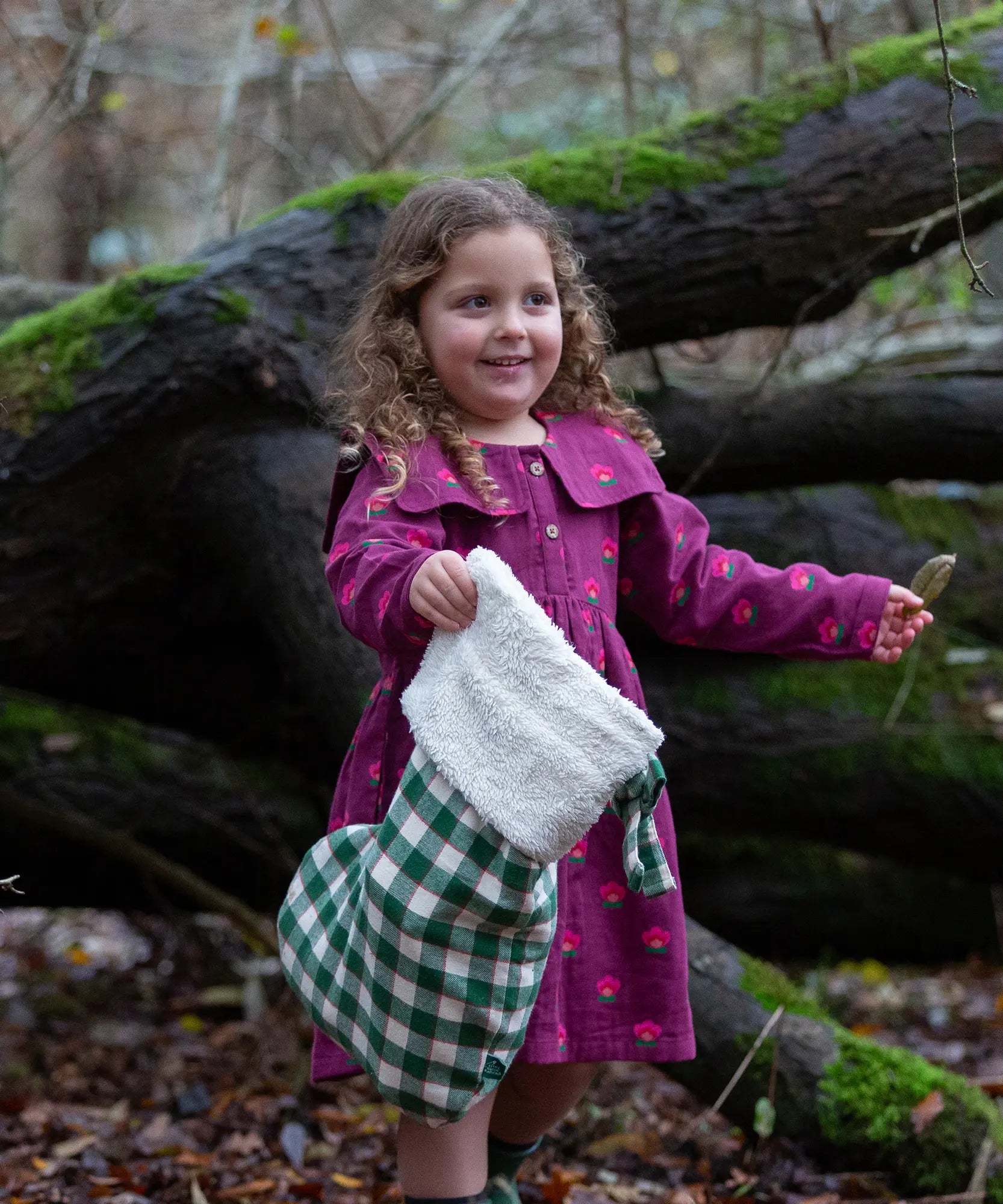 Child holding a Little Green Radicals  olive green check organic cotton stocking.