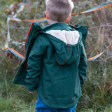 Back of a child wearing a Little Green Radicals olive green recycled waterproof 3 in 1 coat with blue corduroy trousers.