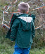 Back of a child wearing a Little Green Radicals olive green recycled waterproof 3 in 1 coat with blue corduroy trousers.