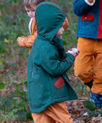 Child wearing a Little Green Radicals olive green recycled waterproof 3 in 1 coat with yellow waterproof dungarees underneath.